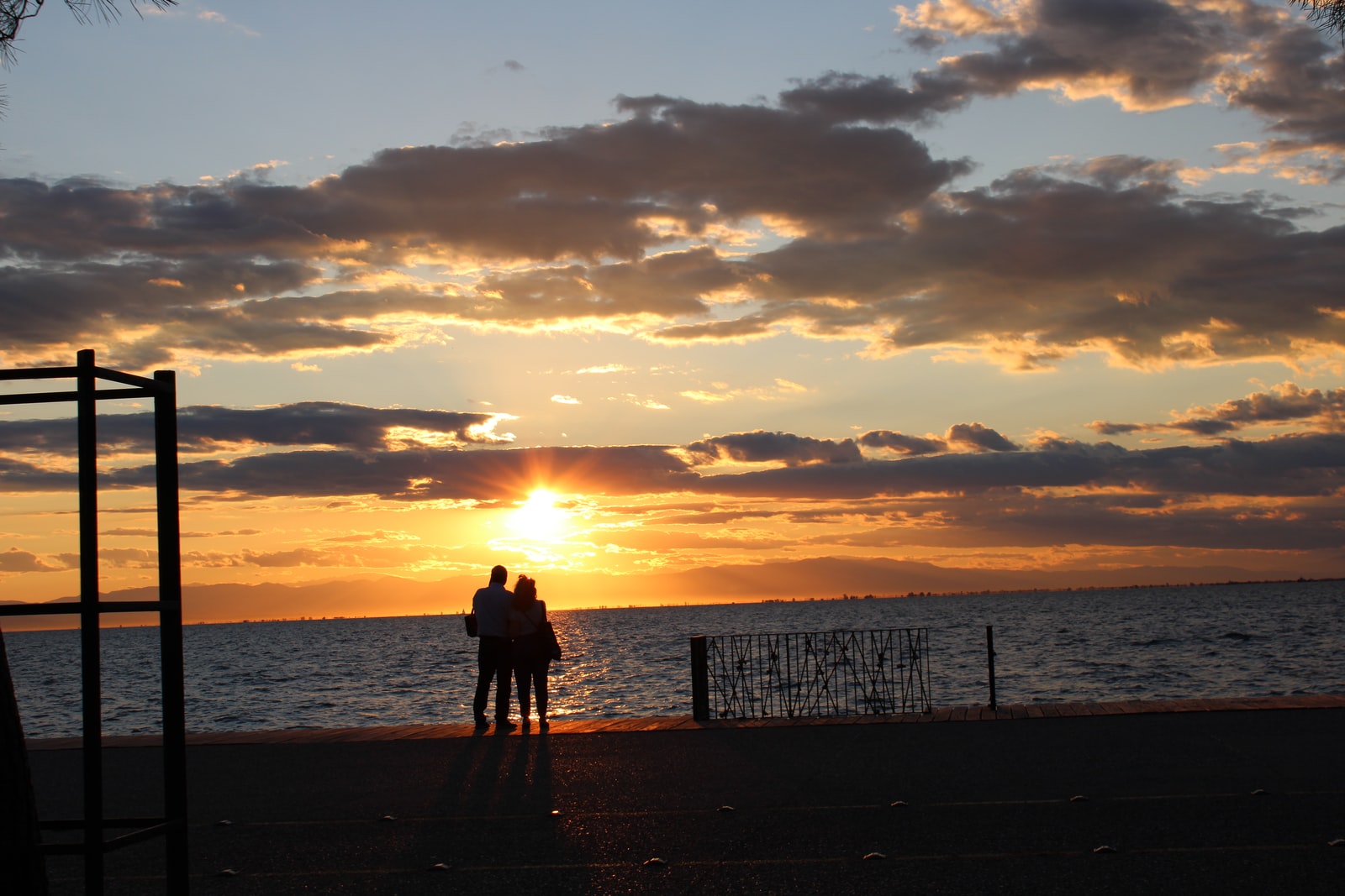 silhouette of 2 person standing on beach during sunset